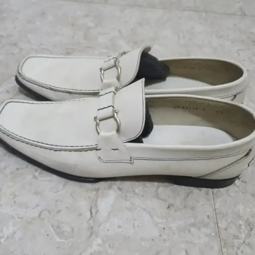 Menjual sepatu putih pria Ferragamo.